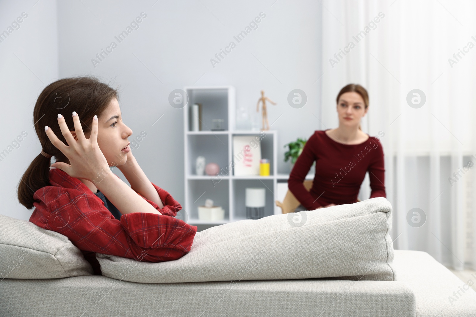 Photo of Professional psychologist working with teenage girl in office, selective focus