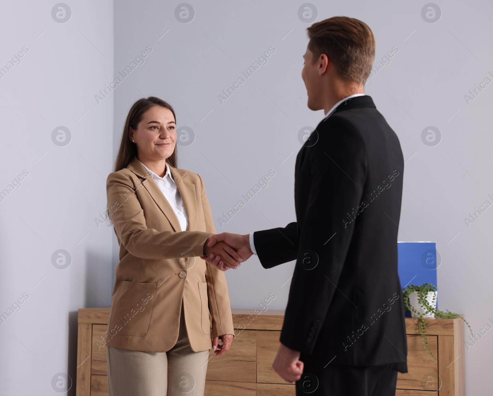 Photo of Man and woman shaking hands in office