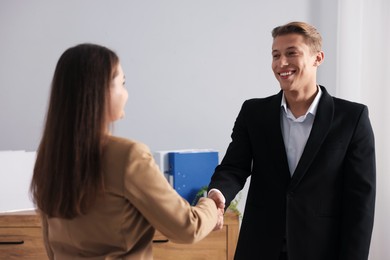 Photo of Man and woman shaking hands in office