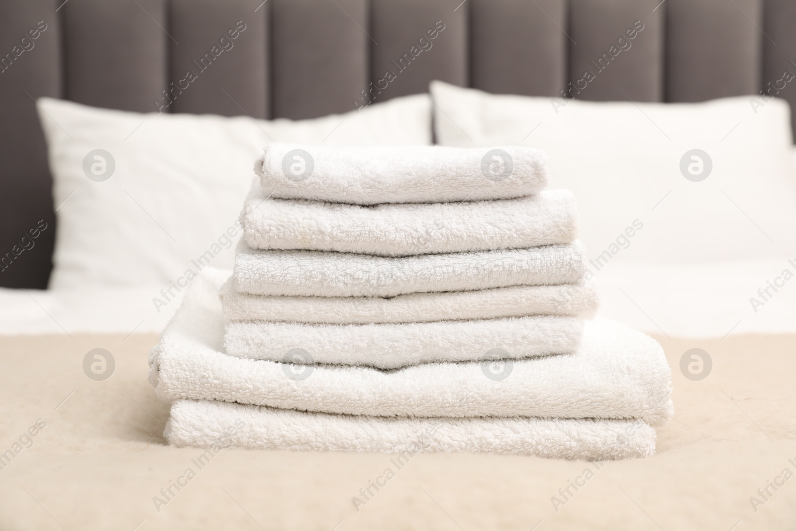 Photo of Stack of white terry towels on bed, closeup