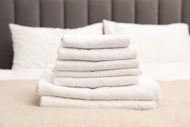 Photo of Stack of white terry towels on bed, closeup