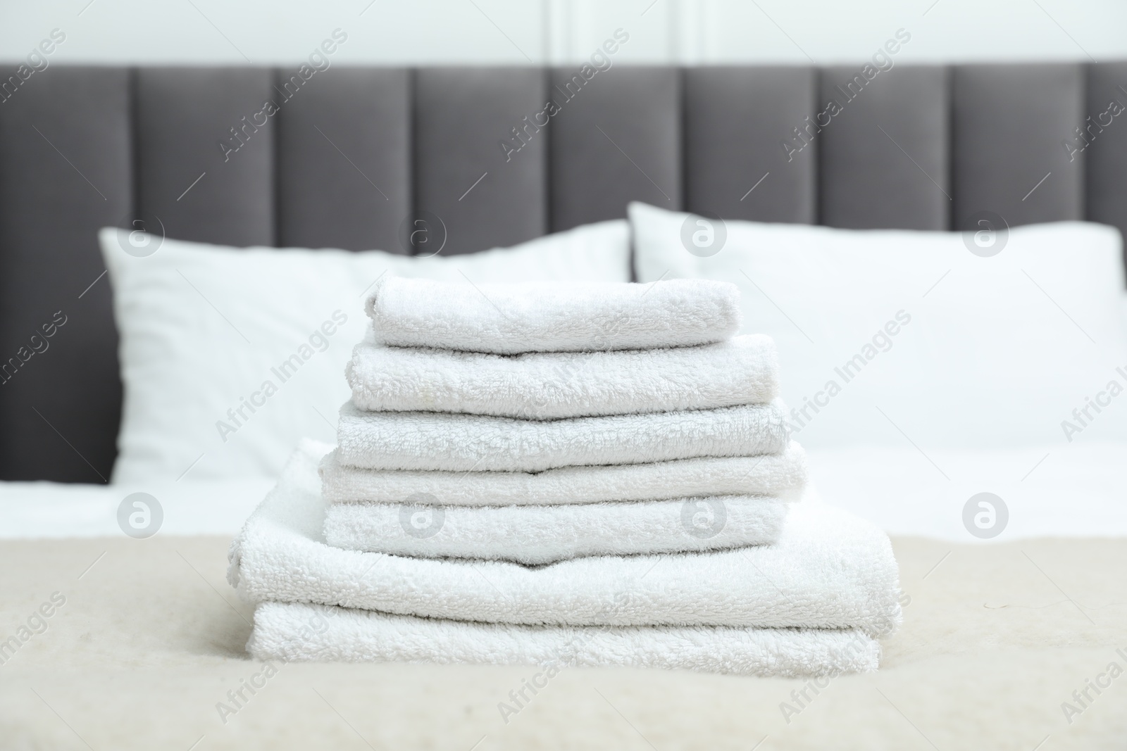 Photo of Stack of white terry towels on bed, closeup