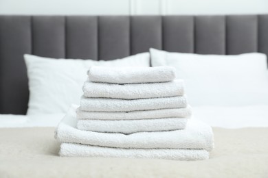 Photo of Stack of white terry towels on bed, closeup