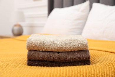 Photo of Stack of terry towels on bed indoors, closeup