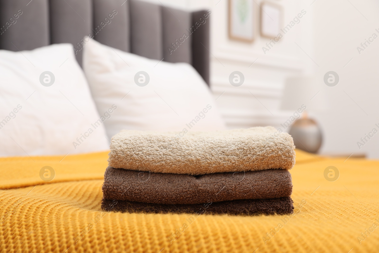 Photo of Stack of terry towels on bed indoors, closeup