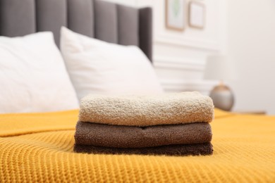 Photo of Stack of terry towels on bed indoors, closeup