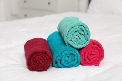 Photo of Bright terry towels on bed indoors, closeup