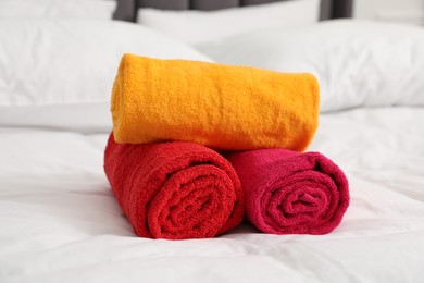 Photo of Bright terry towels on bed linens, closeup