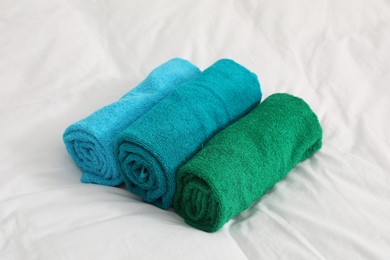 Photo of Bright terry towels on bed linens, closeup