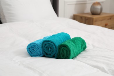 Photo of Bright terry towels on bed indoors, closeup
