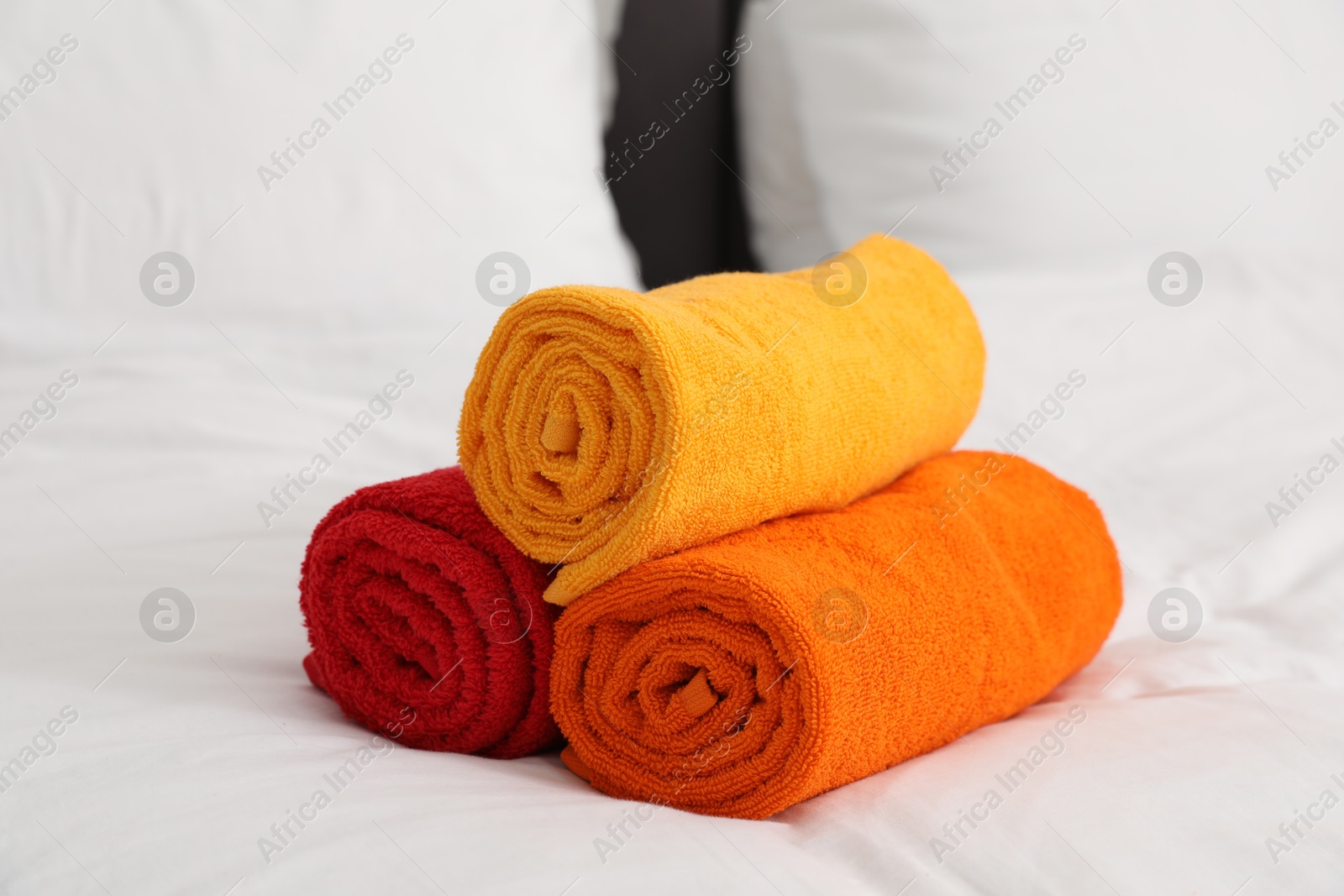 Photo of Bright terry towels on bed linens, closeup