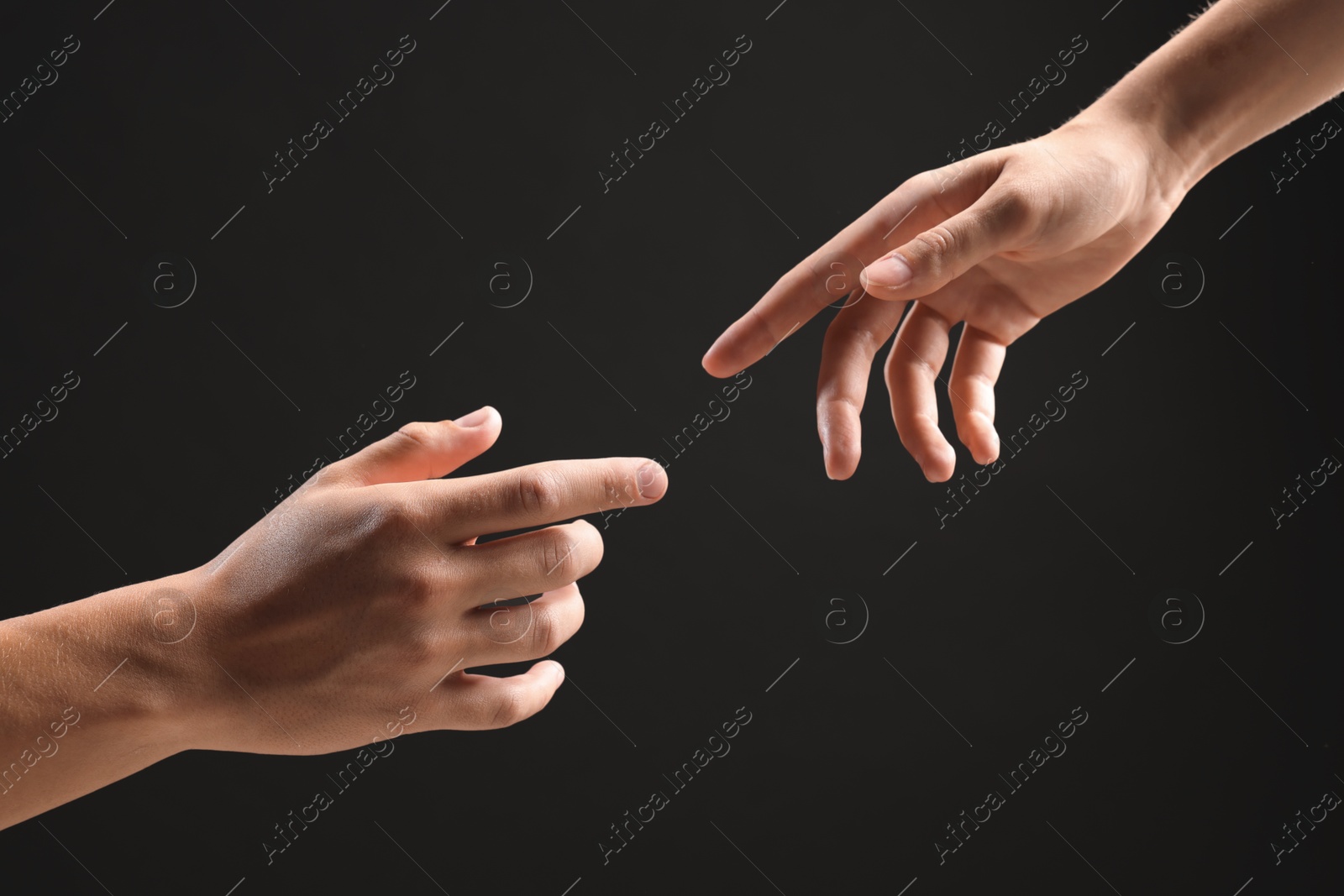 Photo of People joining hands on black background, closeup