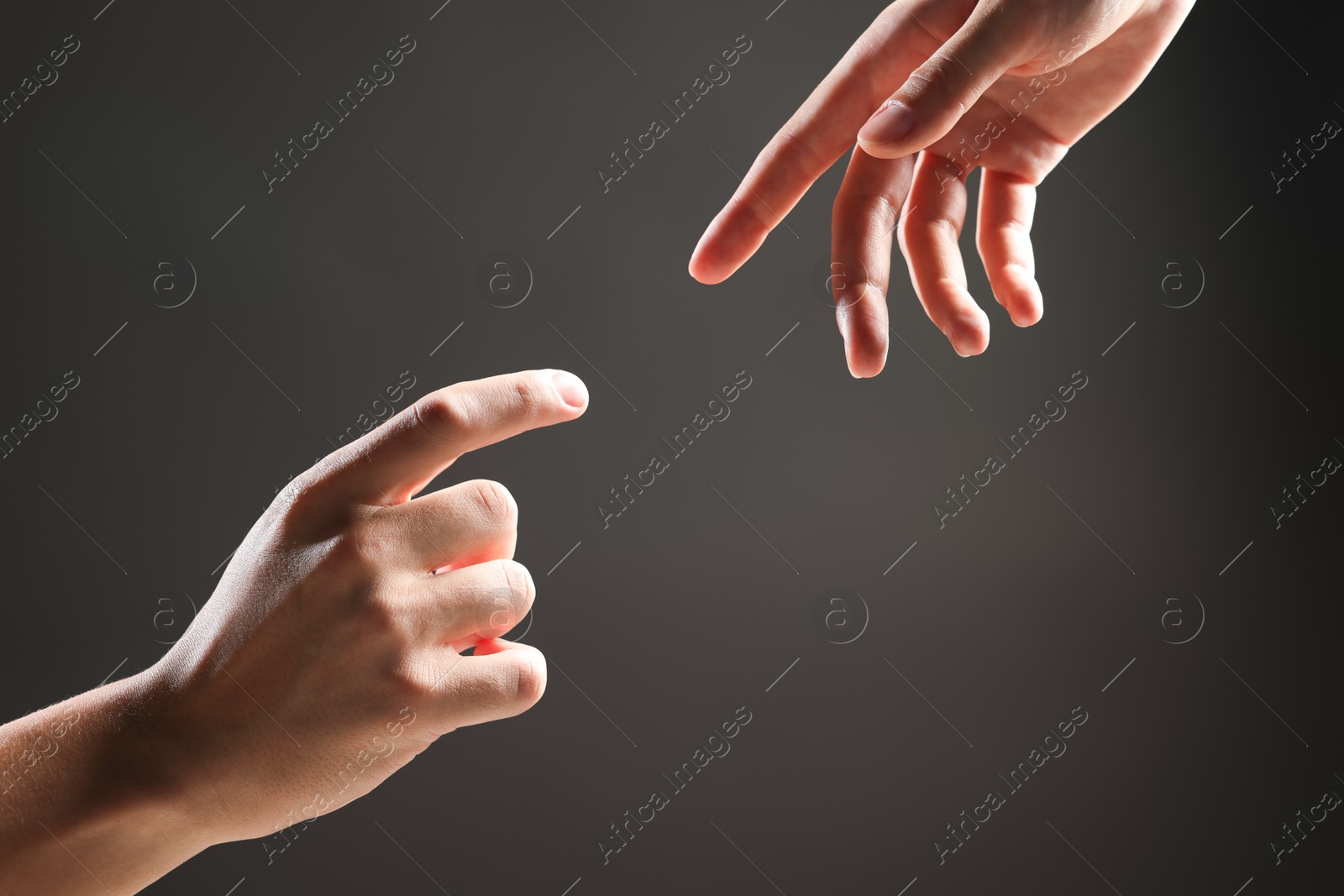 Photo of People joining hands on grey background, closeup