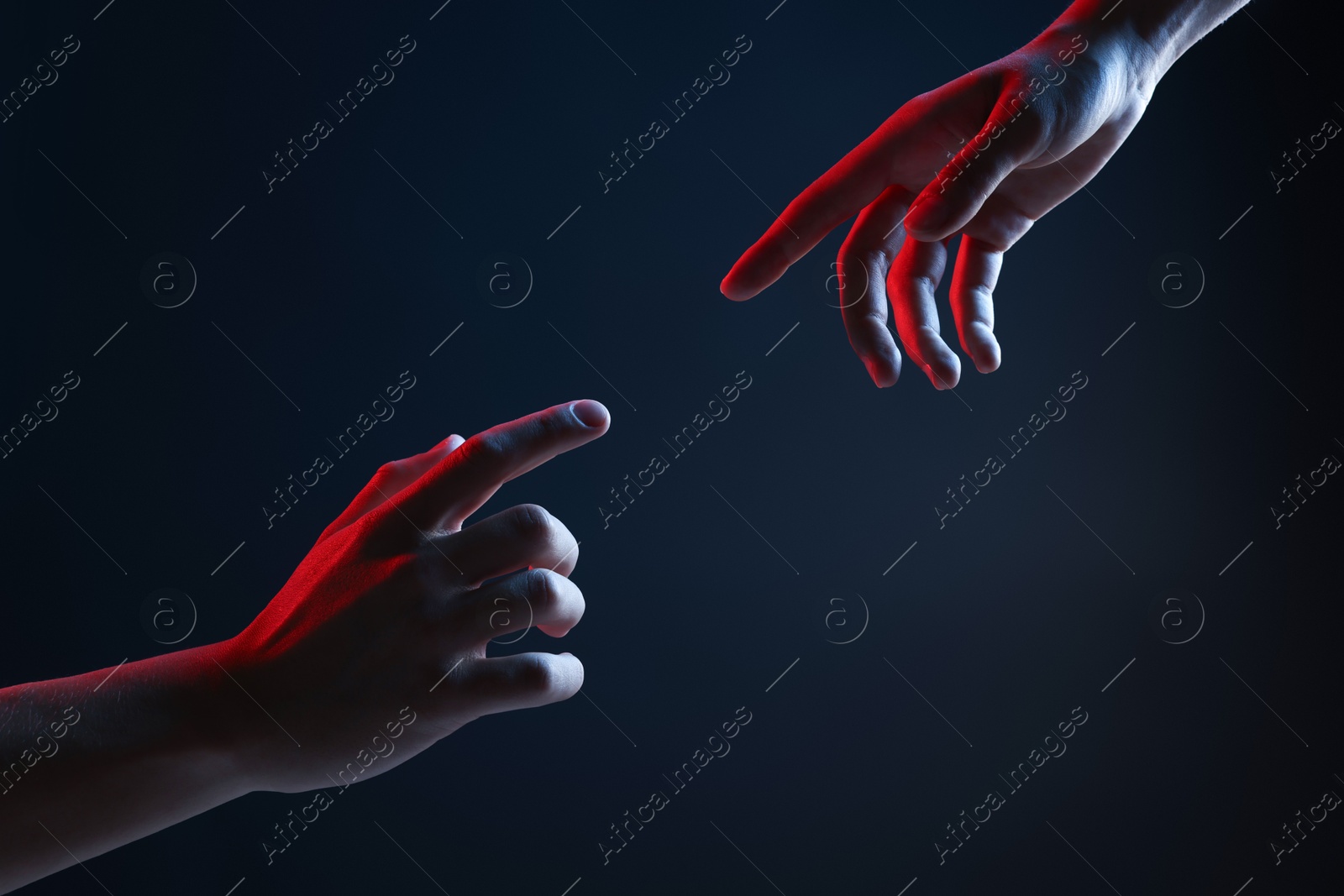 Photo of People joining hands on dark blue background, closeup