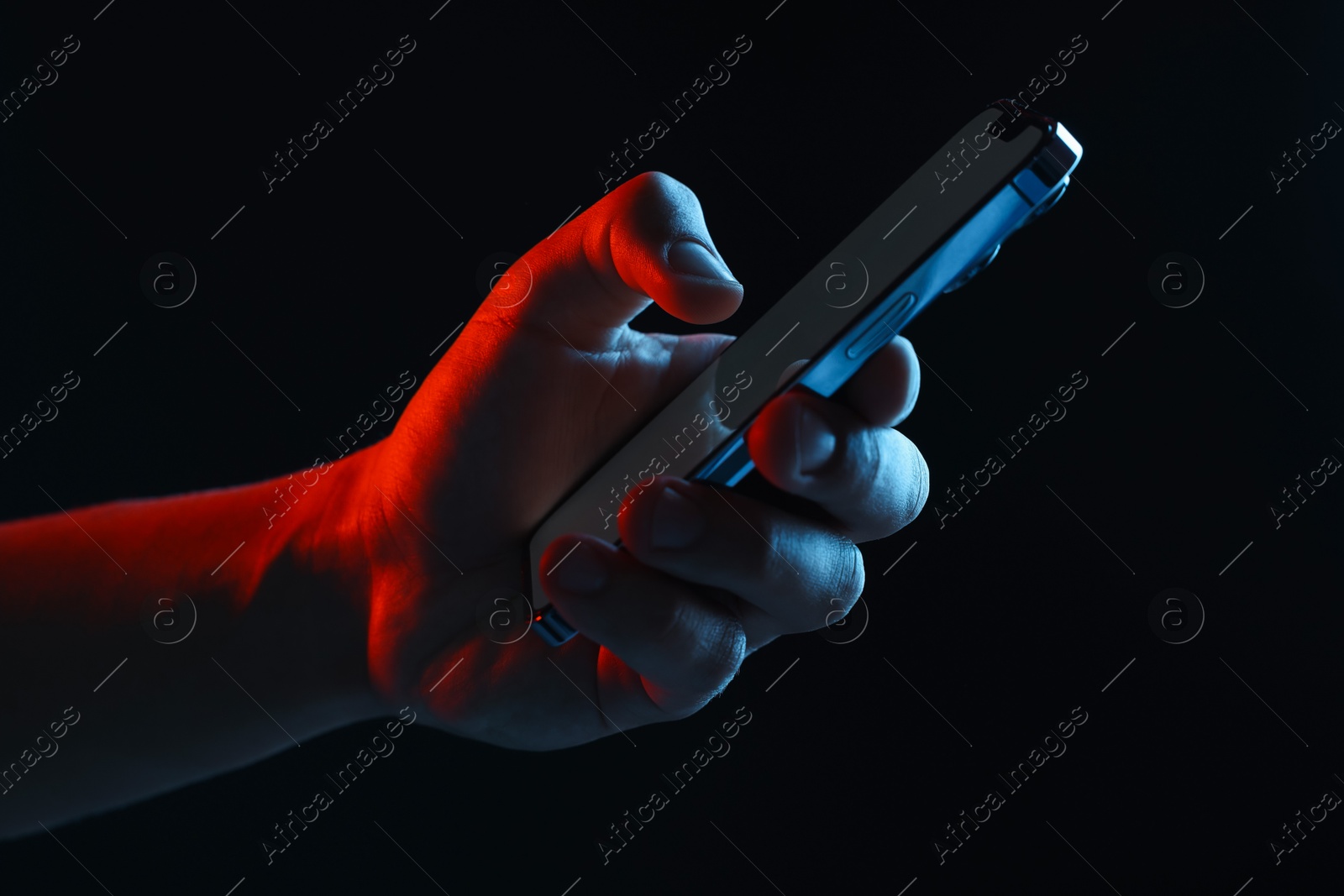 Photo of Man with modern smartphone on black background, closeup