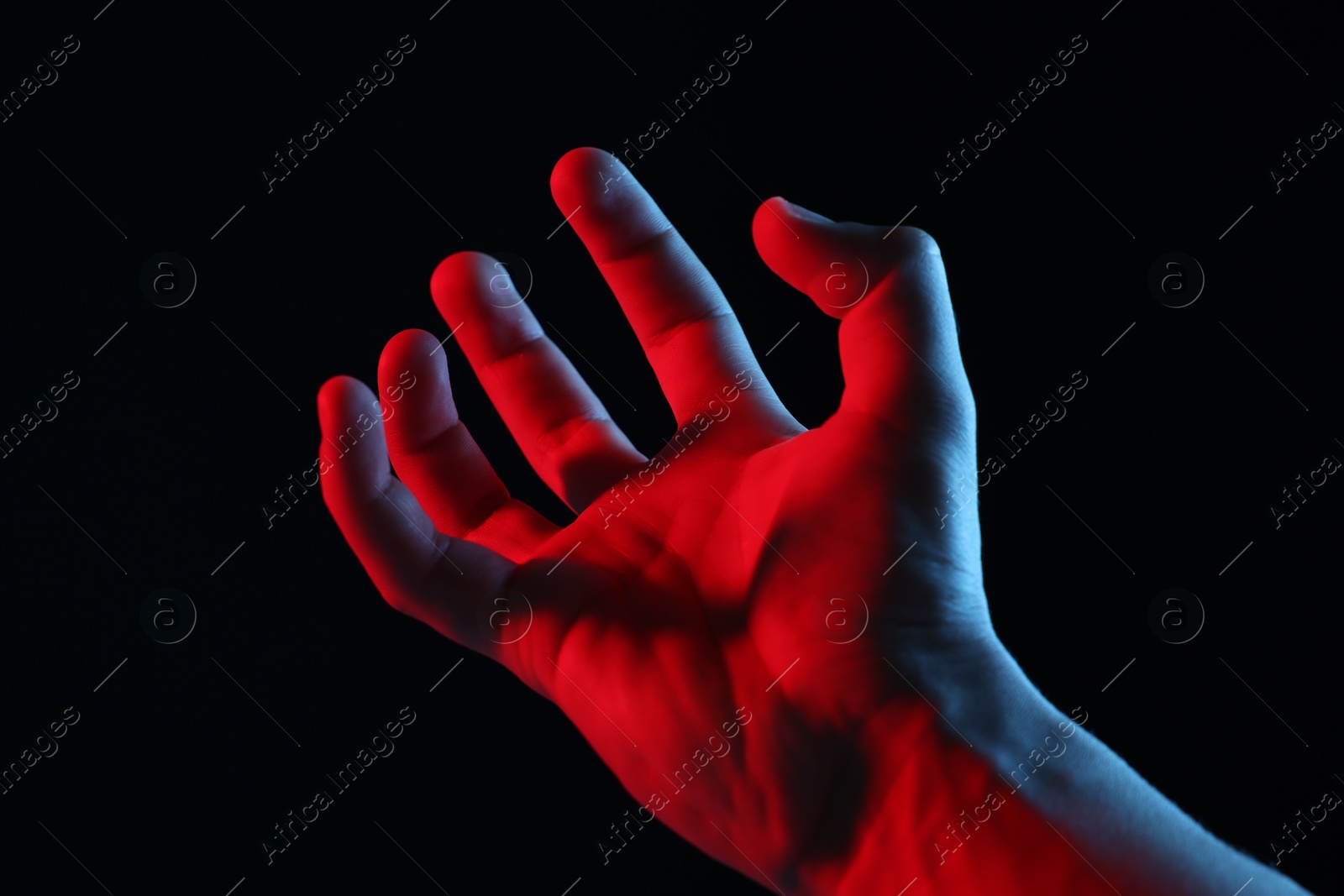 Photo of Man holding something on black background, closeup