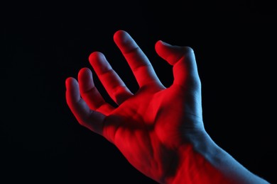 Photo of Man holding something on black background, closeup