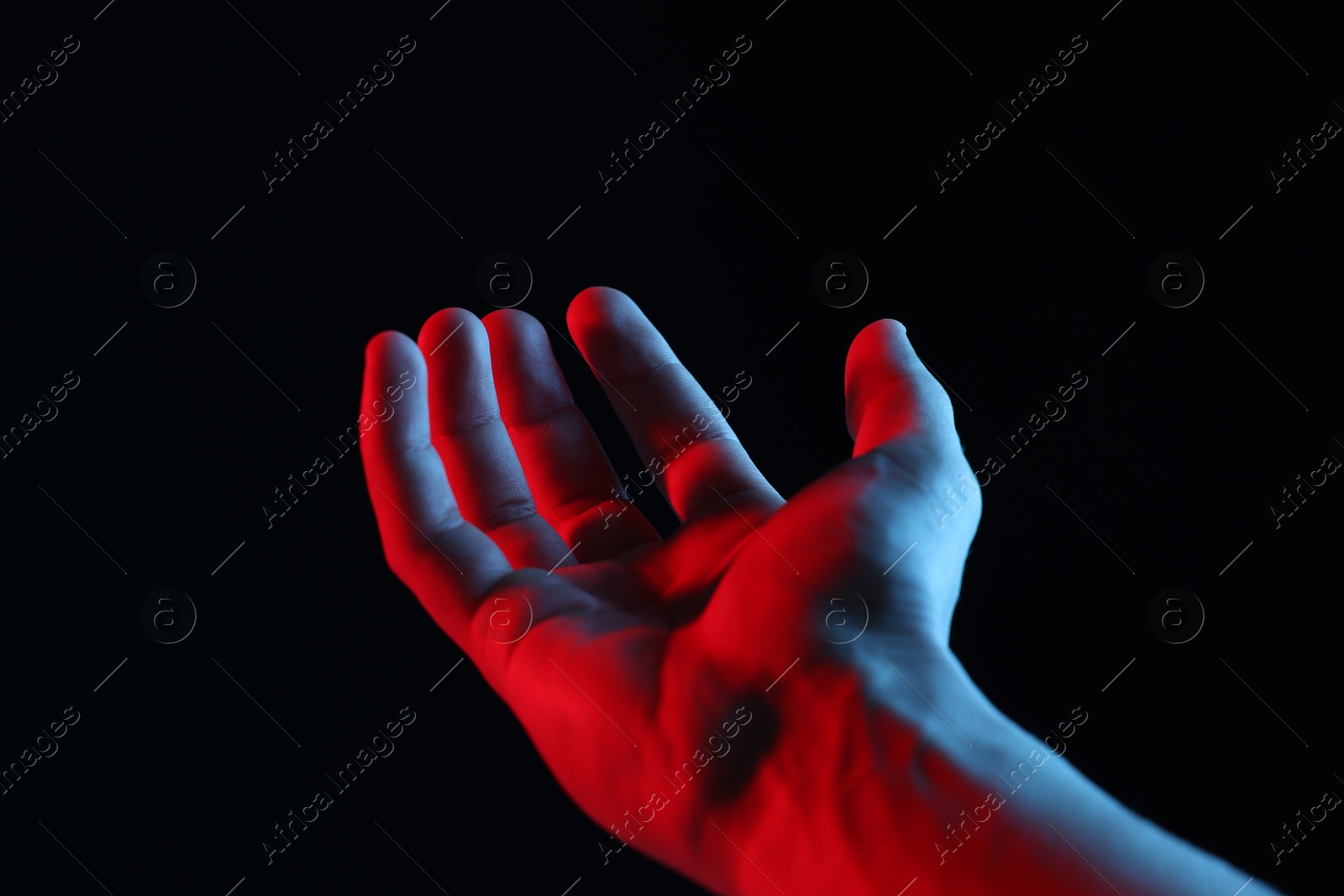 Photo of Man holding something on black background, closeup