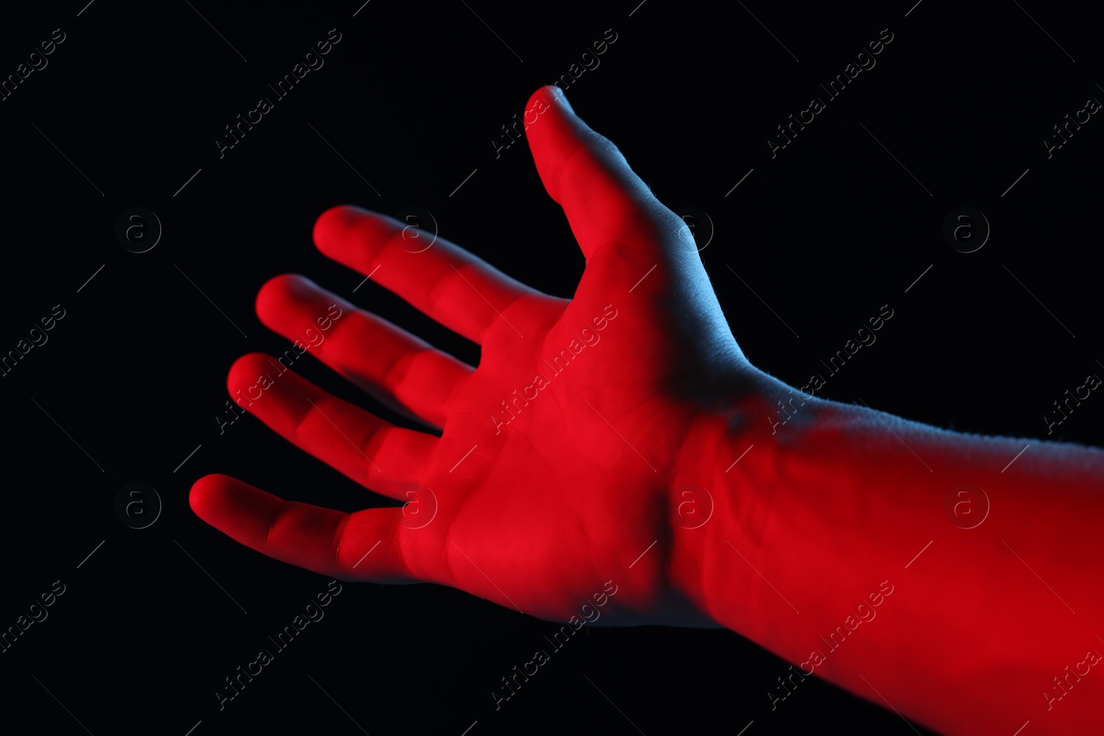 Photo of Man holding something on black background, closeup