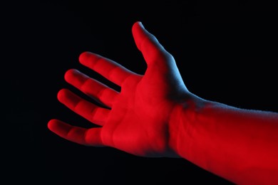 Photo of Man holding something on black background, closeup