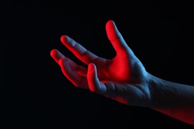 Photo of Man holding something on black background, closeup