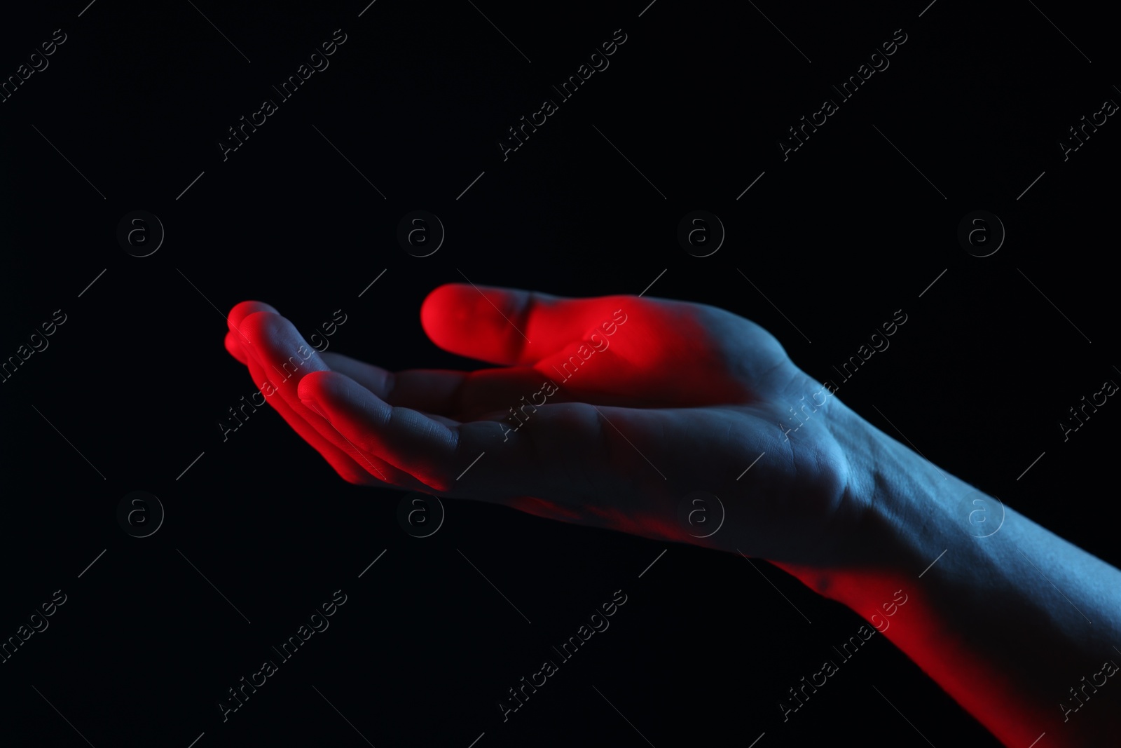 Photo of Man holding something on black background, closeup
