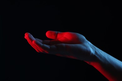 Photo of Man holding something on black background, closeup