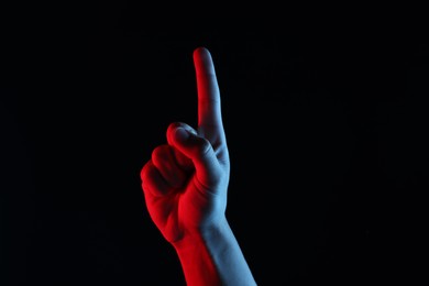 Photo of Man touching something on black background, closeup