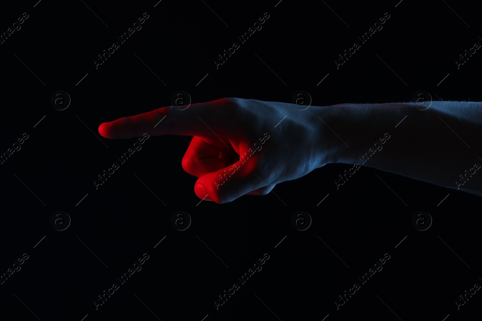 Photo of Man touching something on black background, closeup