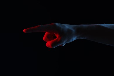 Photo of Man touching something on black background, closeup