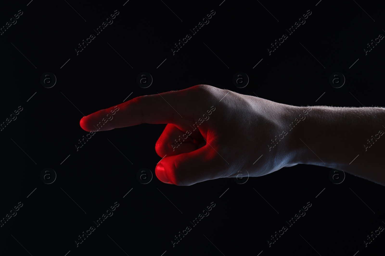 Photo of Man touching something on black background, closeup