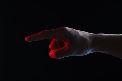 Photo of Man touching something on black background, closeup