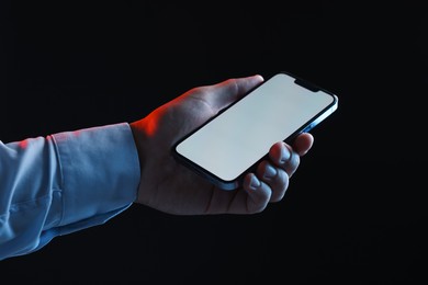Photo of Man with modern smartphone on black background, closeup. Mockup for design