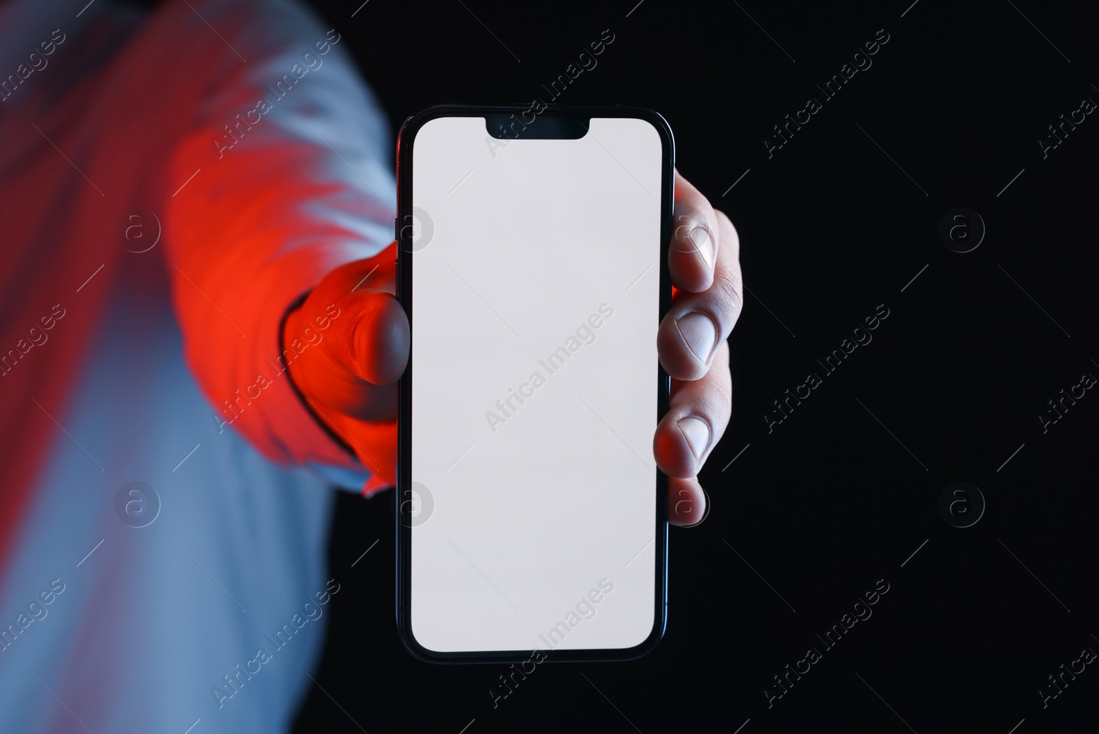 Photo of Man with modern smartphone on black background, closeup. Mockup for design