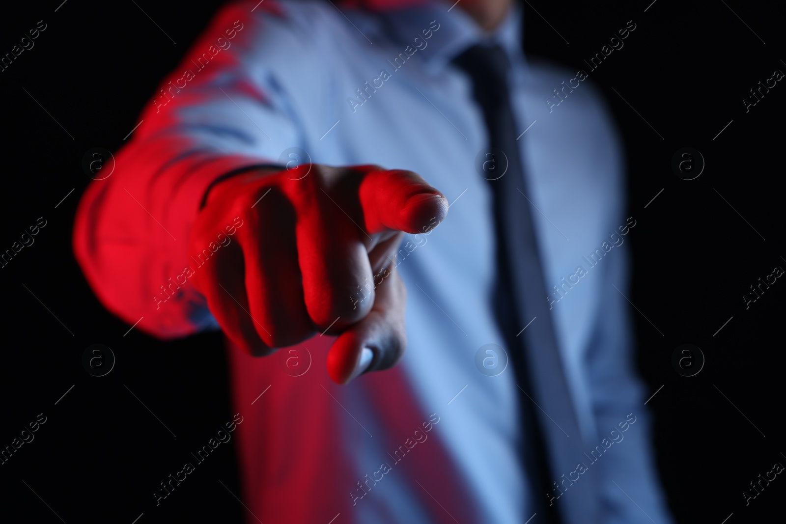 Photo of Man touching something on black background, closeup