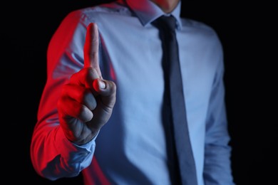 Photo of Man touching something on black background, closeup