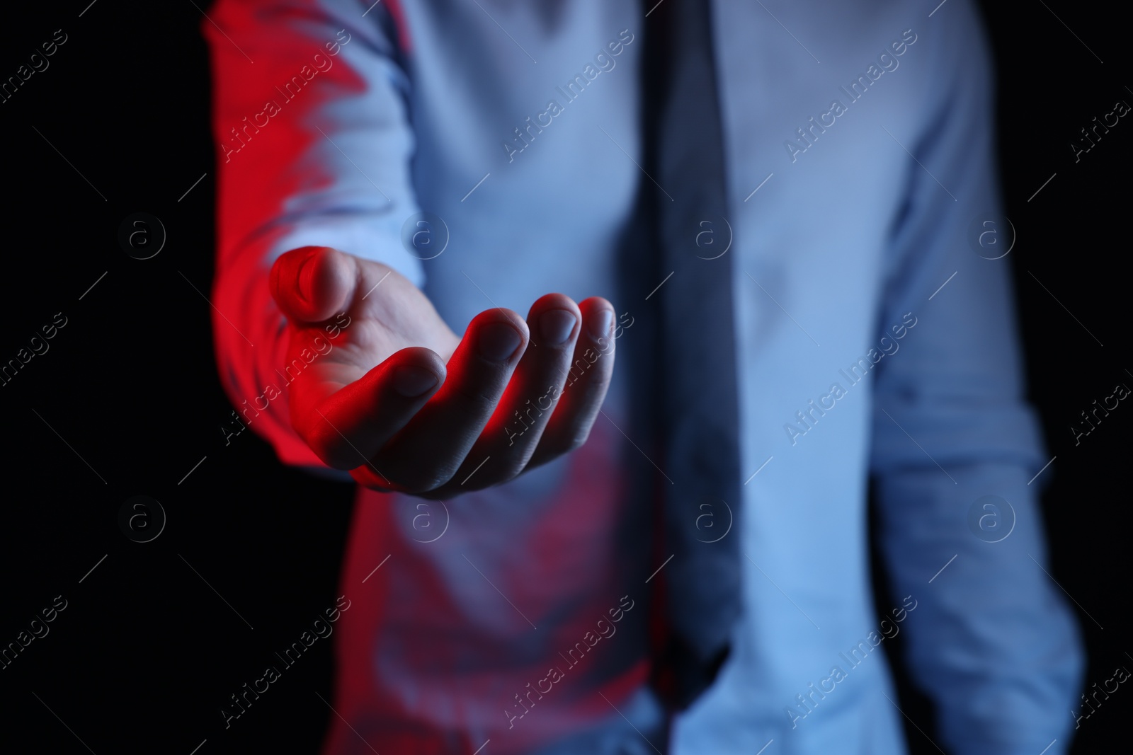 Photo of Man holding something on black background, closeup