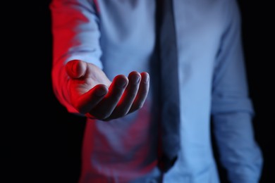 Photo of Man holding something on black background, closeup