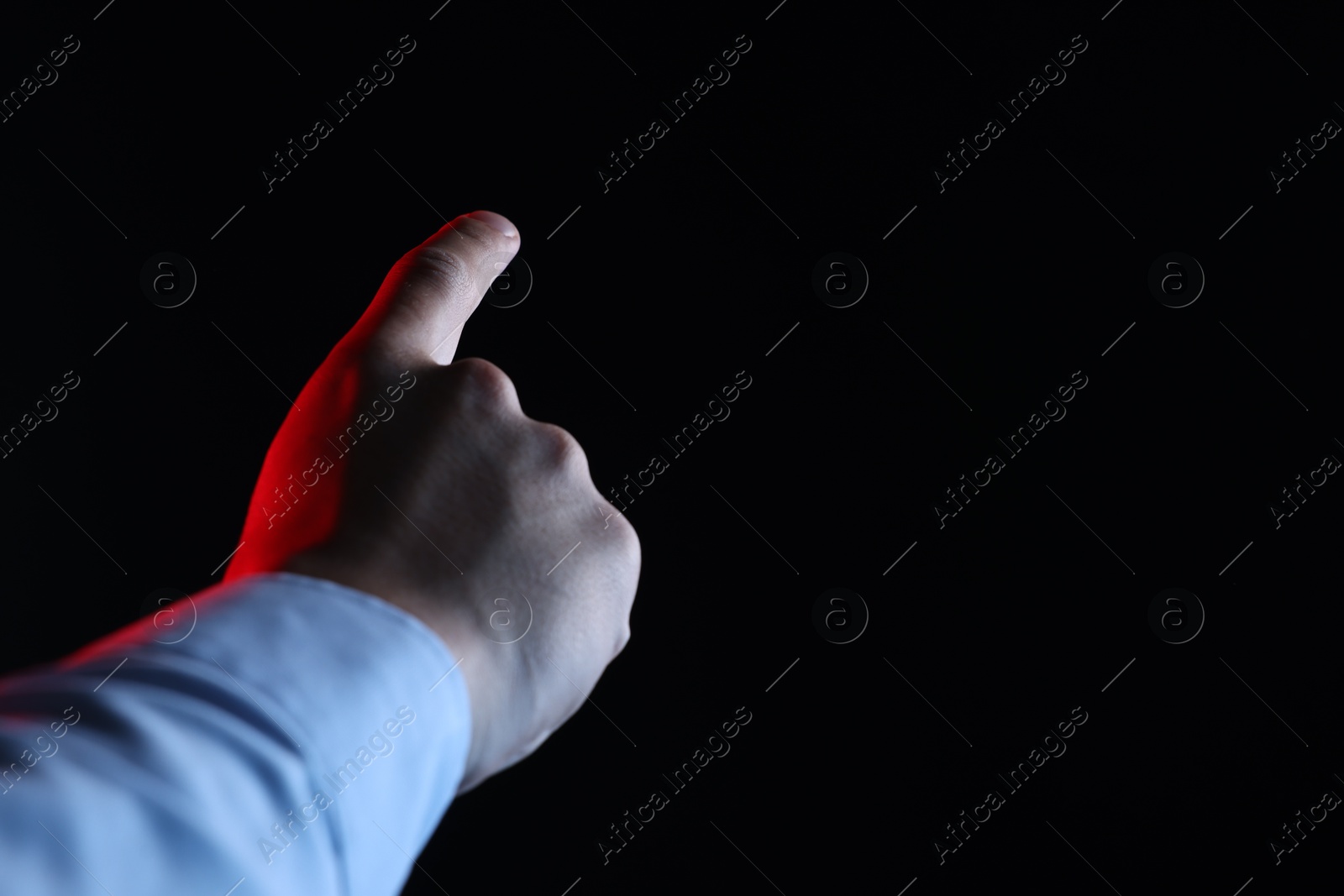 Photo of Man touching something on black background, closeup. Space for text
