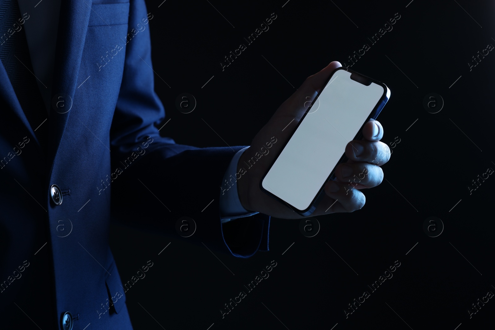 Photo of Man with modern smartphone on black background, closeup. Mockup for design