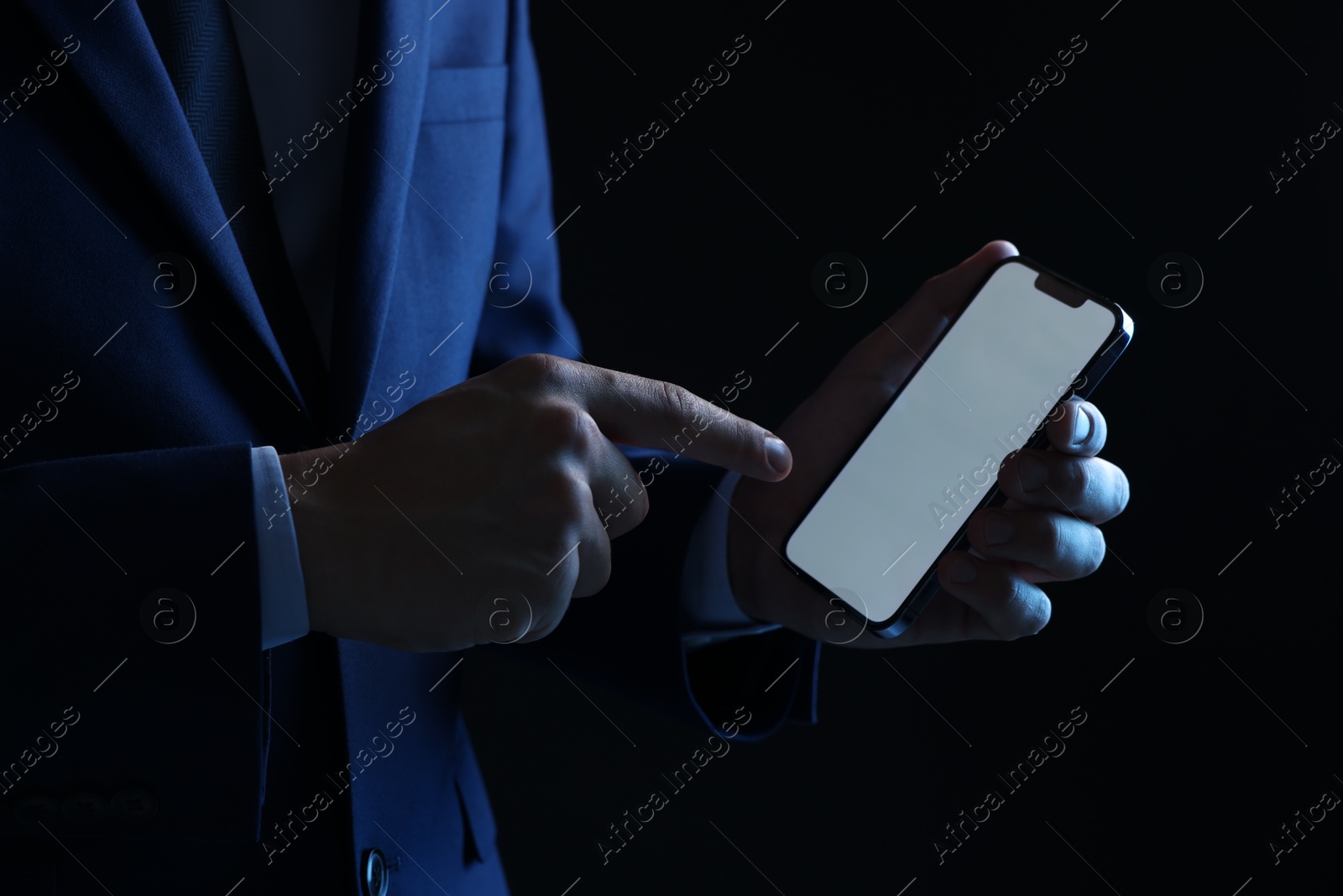 Photo of Man with modern smartphone on black background, closeup. Mockup for design