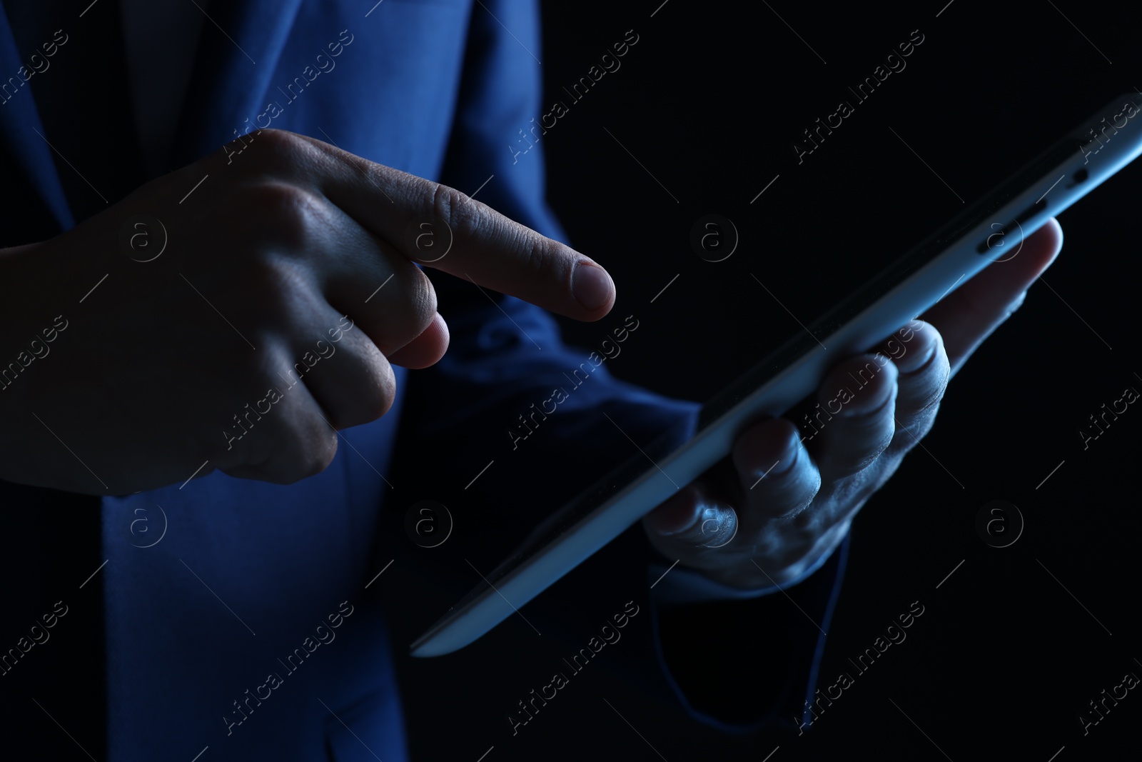 Photo of Man with modern tablet on black background, closeup