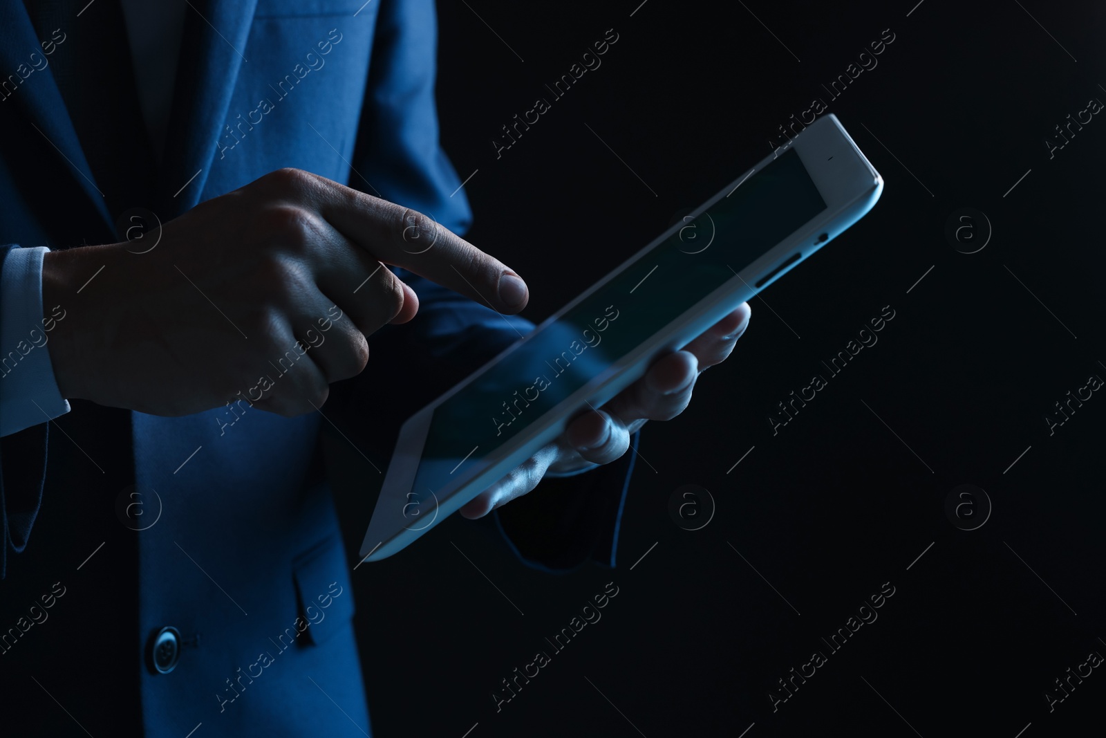 Photo of Man with modern tablet on black background, closeup