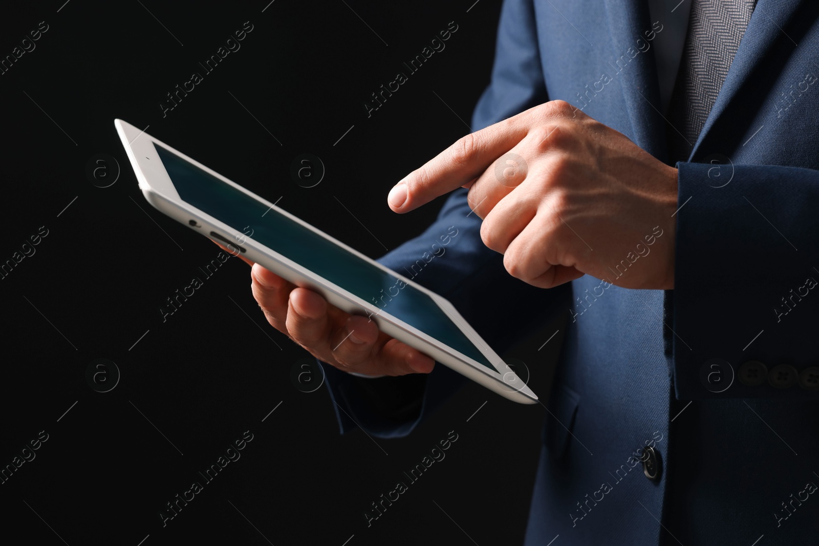 Photo of Man with modern tablet on black background, closeup