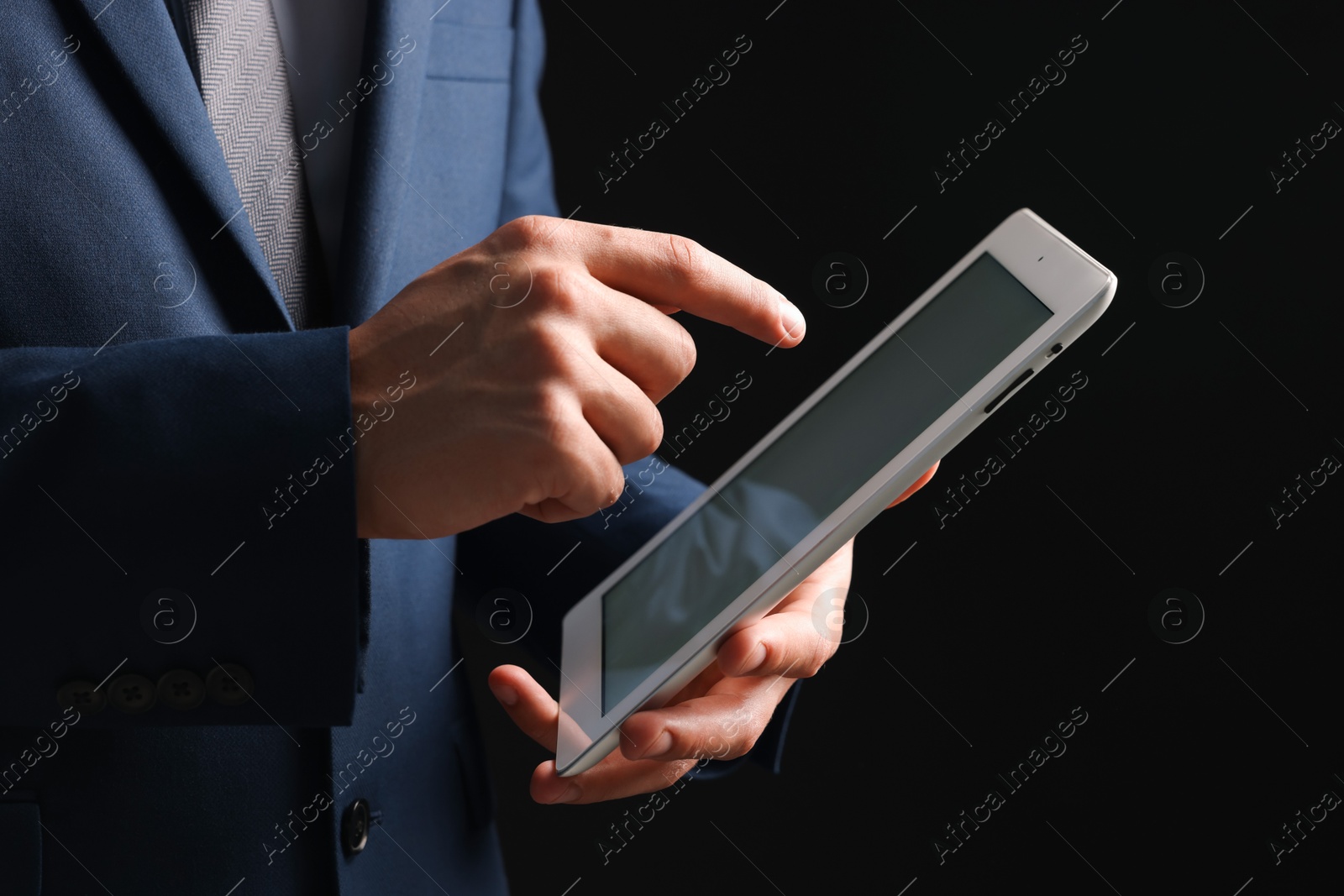 Photo of Man with modern tablet on black background, closeup