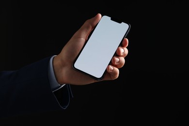 Photo of Man with modern smartphone on black background, closeup. Mockup for design