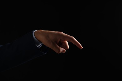 Photo of Man touching something on black background, closeup