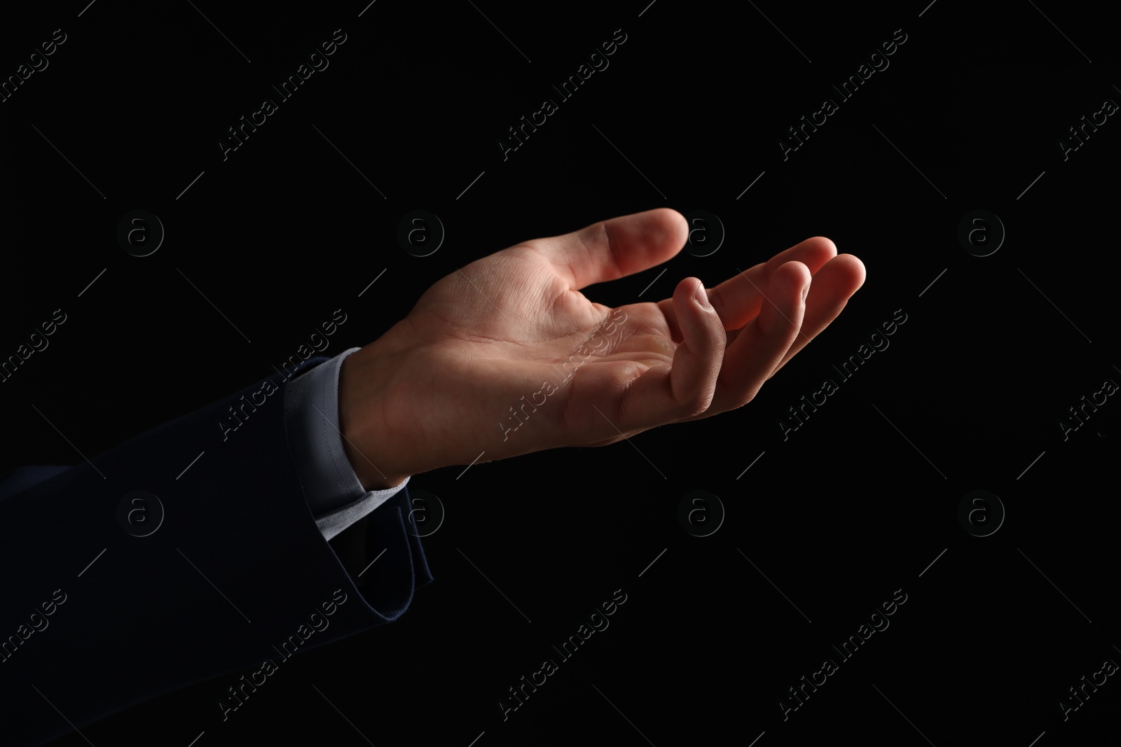 Photo of Man holding something on black background, closeup