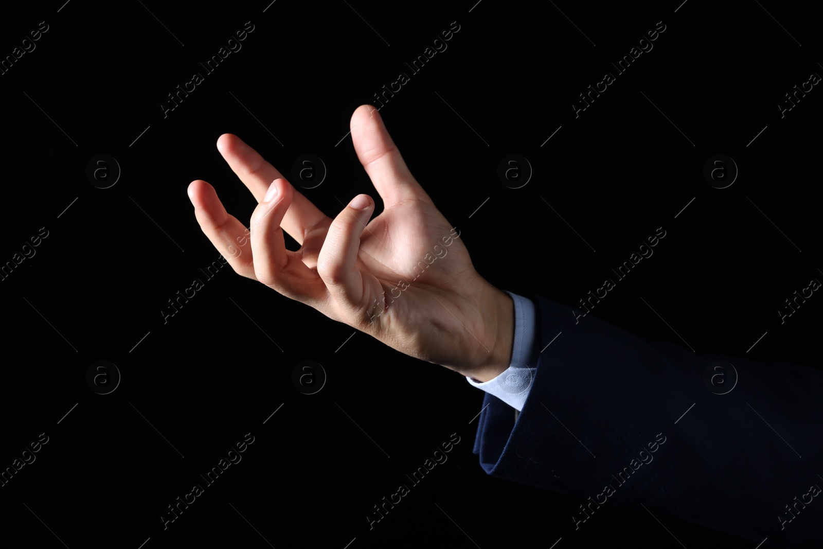 Photo of Man holding something on black background, closeup