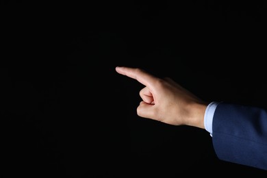 Photo of Man touching something on black background, closeup. Space for text